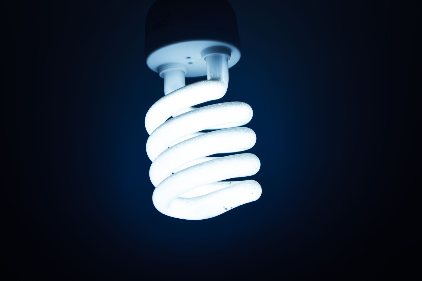 Glödande spiralformad lampa i blått mörker