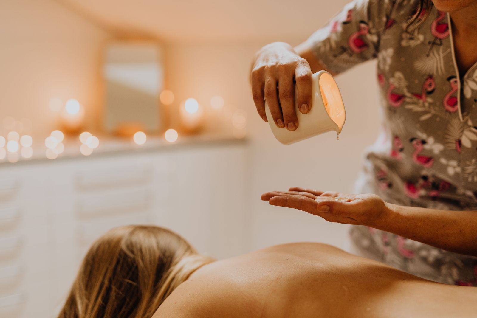 Händer som häller upp massageolja