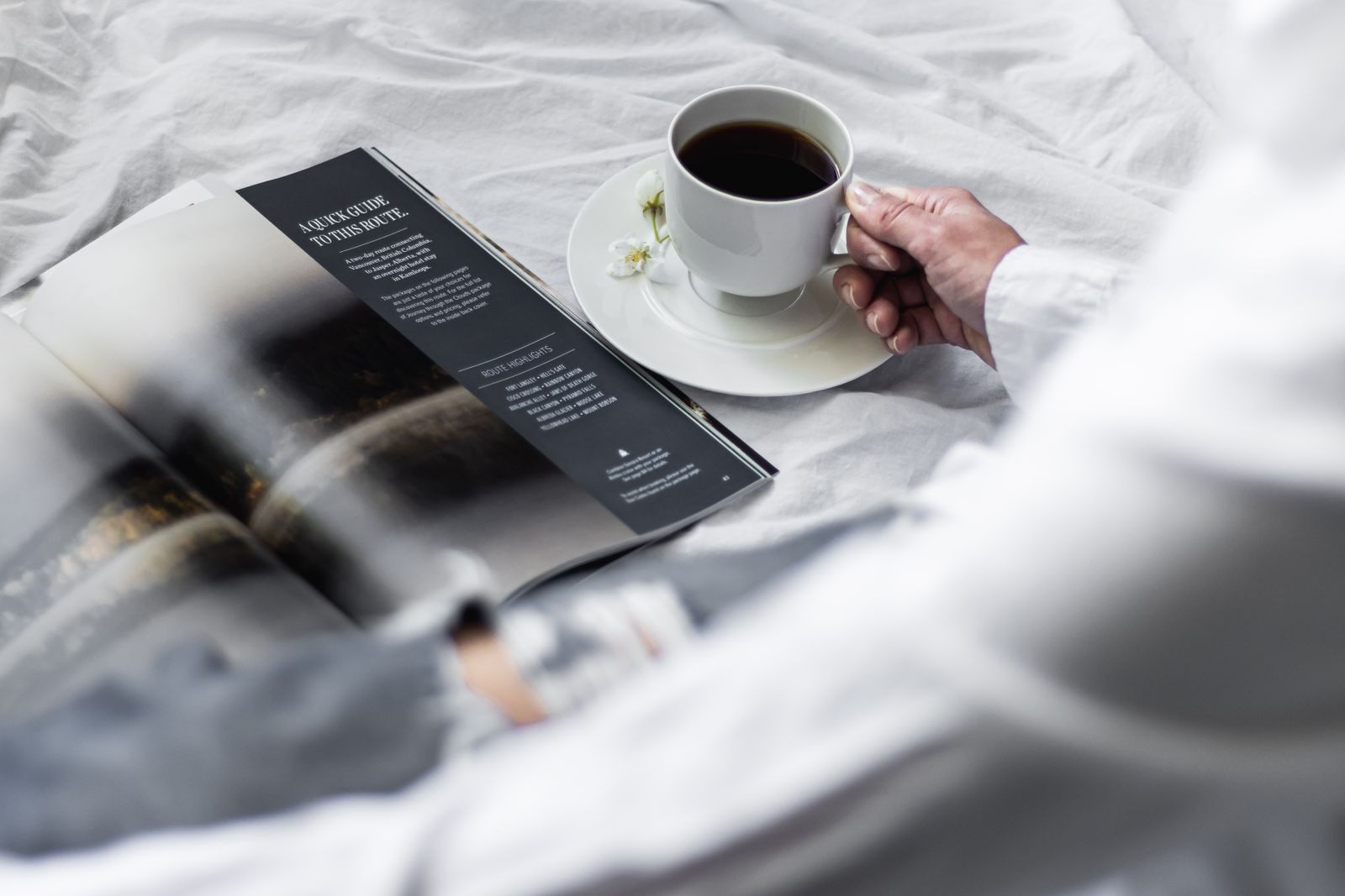 Händer med tidning och kaffe i ombonad miljö